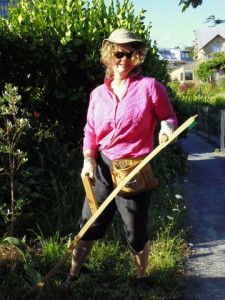 Amanda, scything long grass in the orchard for compost and mulch.